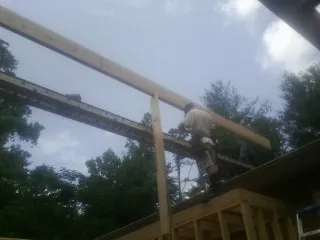 Carpenter setting a ridge beam over a new addition frame — Ice Dam Removal by Roofing Brothers in Parish