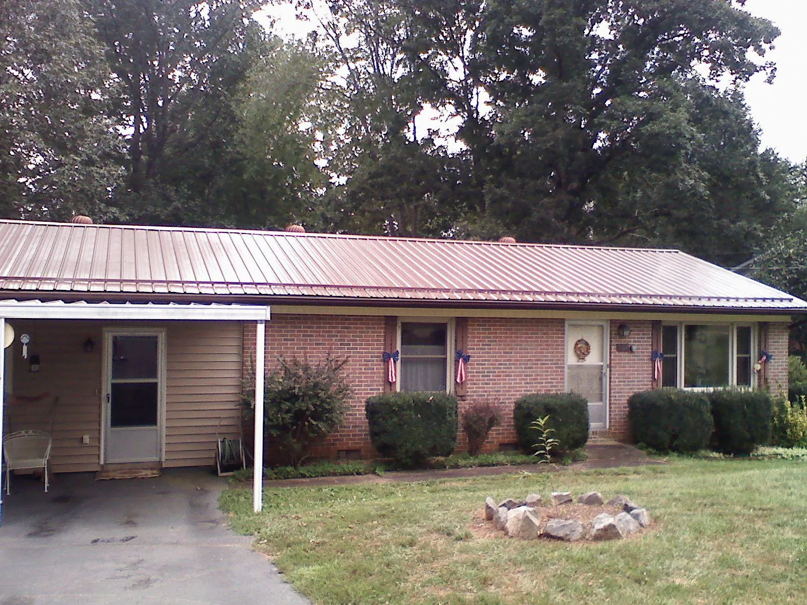 Bronze metal roof and carport on a brick ranch home — Roof Repair work by our crew in Parish